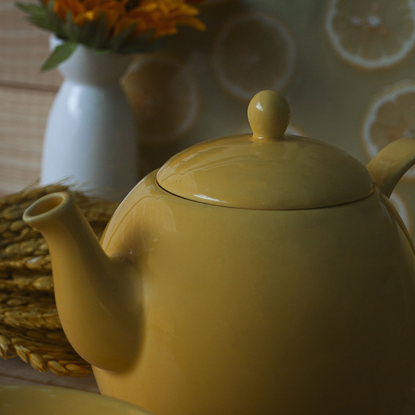 A ceramic teapot finished in a clear yellow glaze.