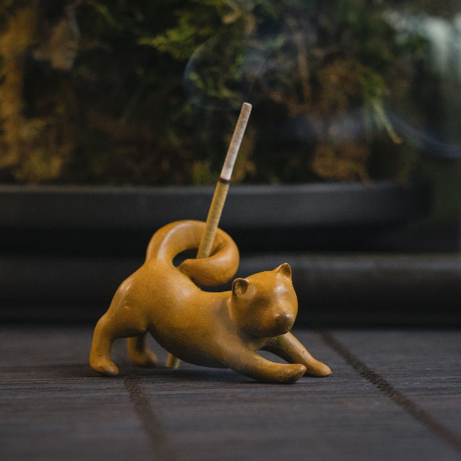 A clay sculpture of a fox that doubles as an incense holder, photographed indoors.