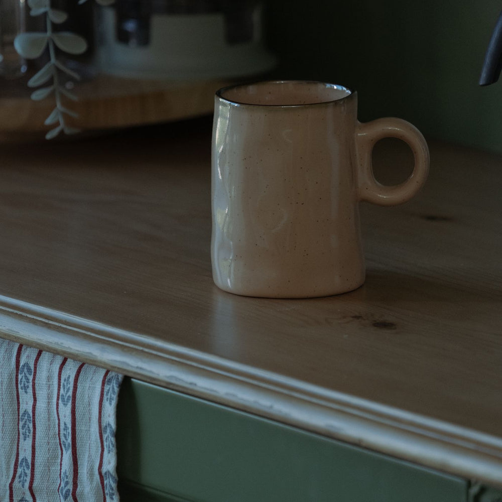 A minimalist mug with a quiet plain finish, shown on a rustic wooden table.