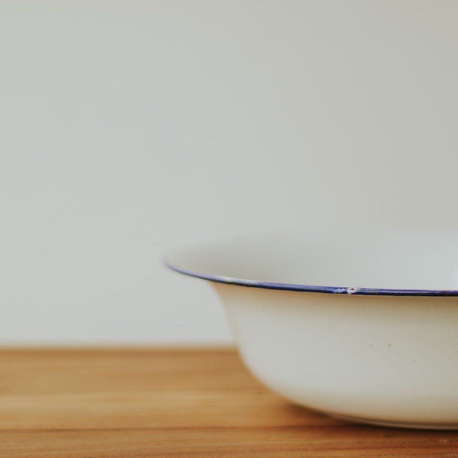 A minimalist porcelain bowl photographed on a wooden surface, simple and quietly elegant.