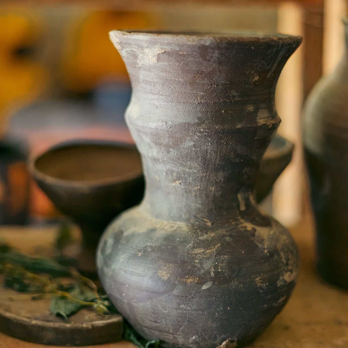 A traditional African clay pot, photographed on a rustic shelf as a showcase of artisan craftsmanship.