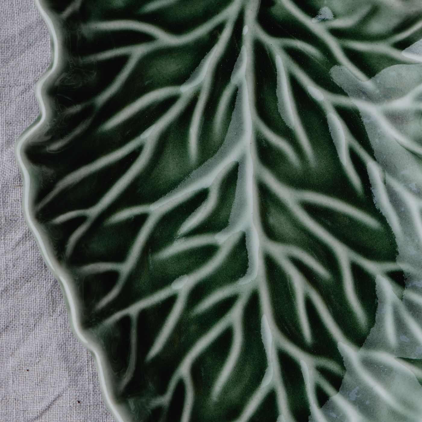 A detailed ceramic platter formed in the shape of a leaf, equally at home serving or on display.