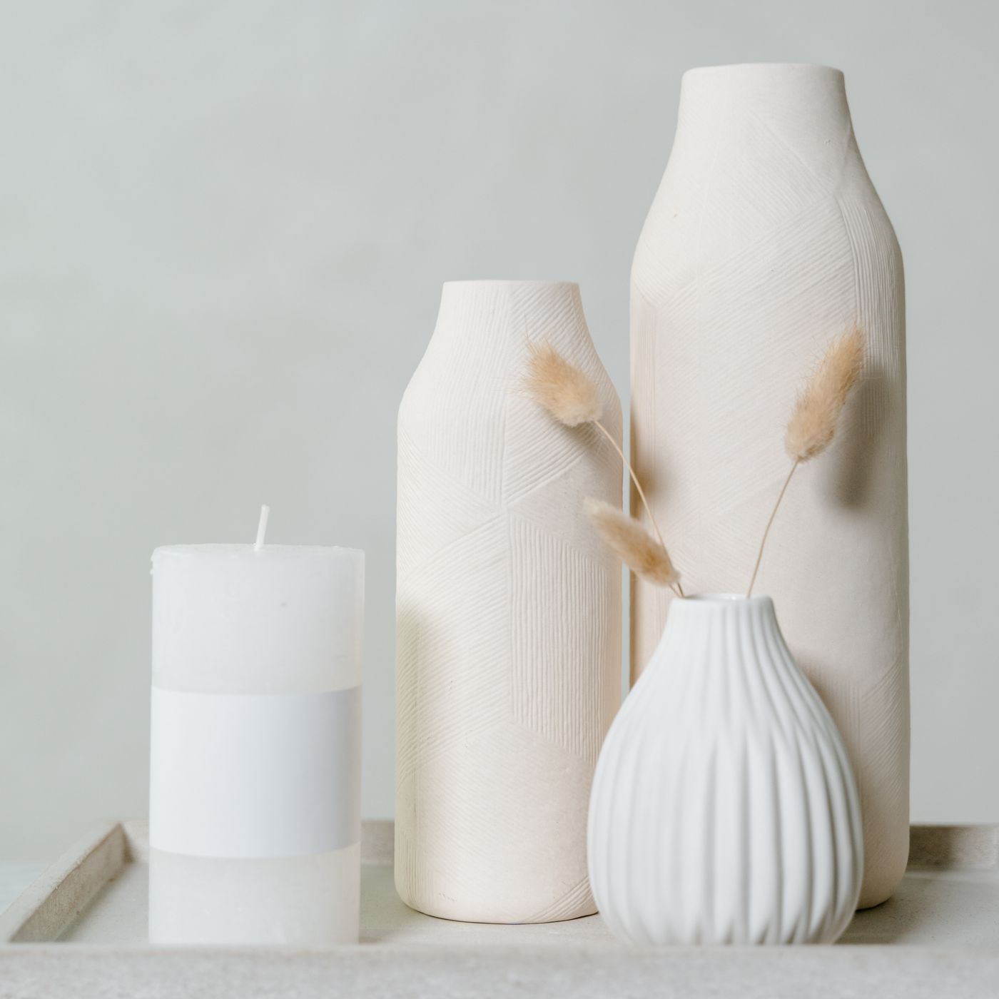A white ceramic vase, shown standing on a tray.